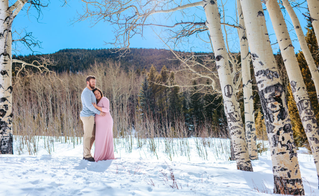 Parents to be at Maternity sessions amount the snowy aspens in the mountains of Colorado 