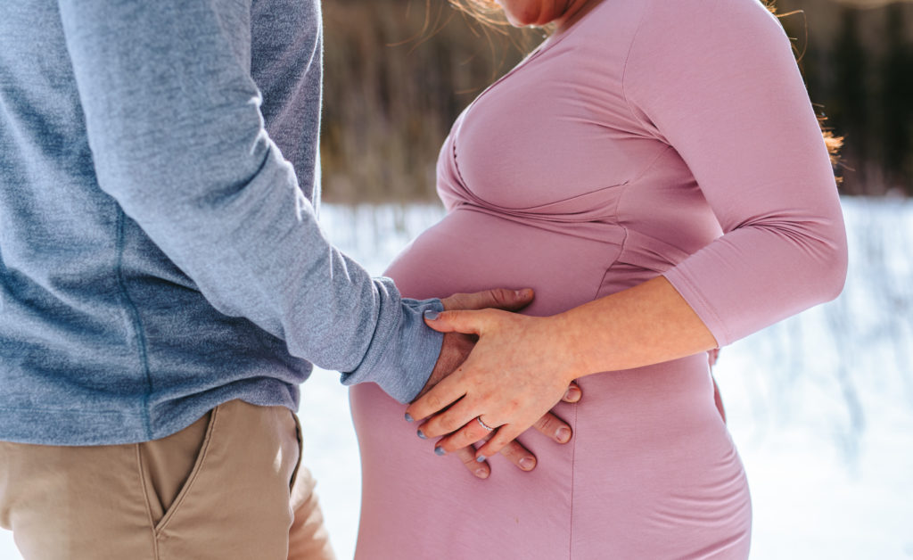 Parents to be at maternity session in the snowy mountains of Colorado 