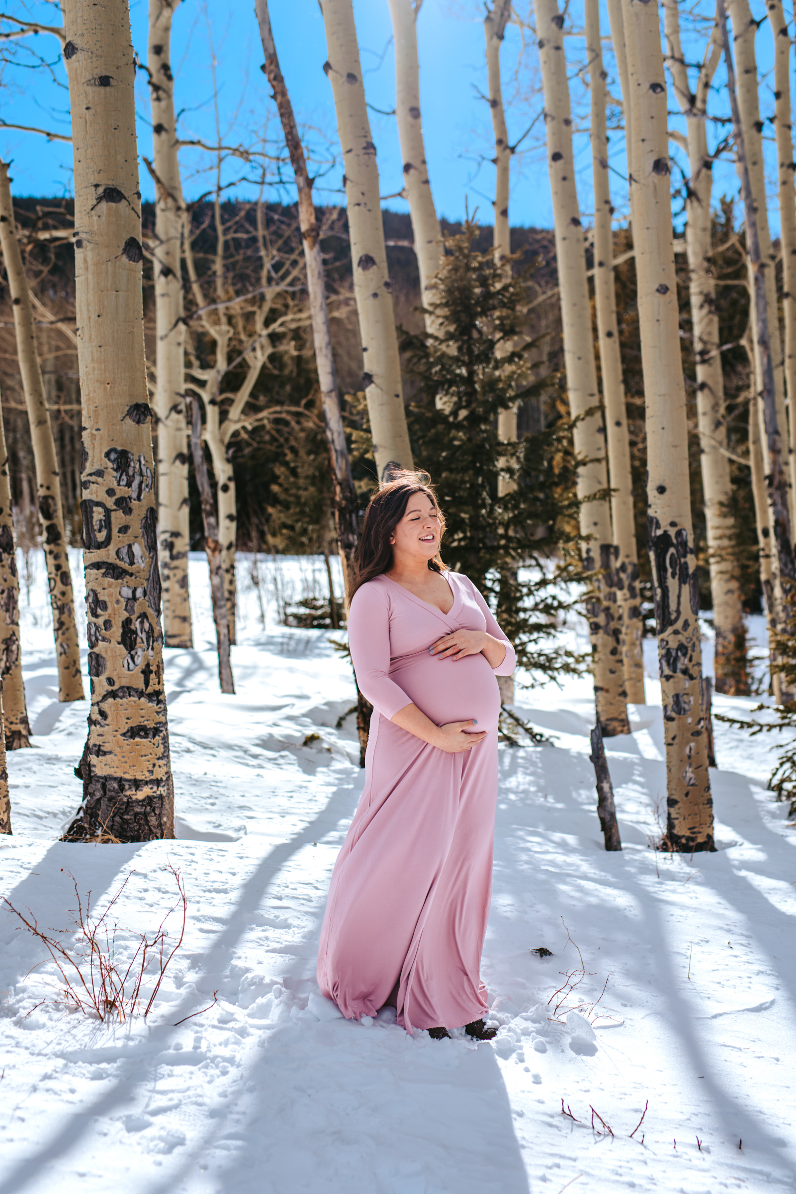 Mama to be embracing pregnancy among the aspen trees in the mountains of Colorado 