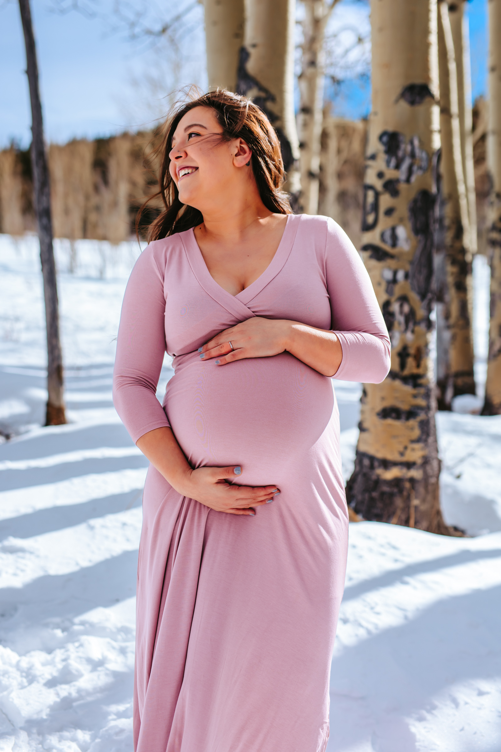 Mama to be embracing pregnancy among the aspen trees in the mountains of Colorado 