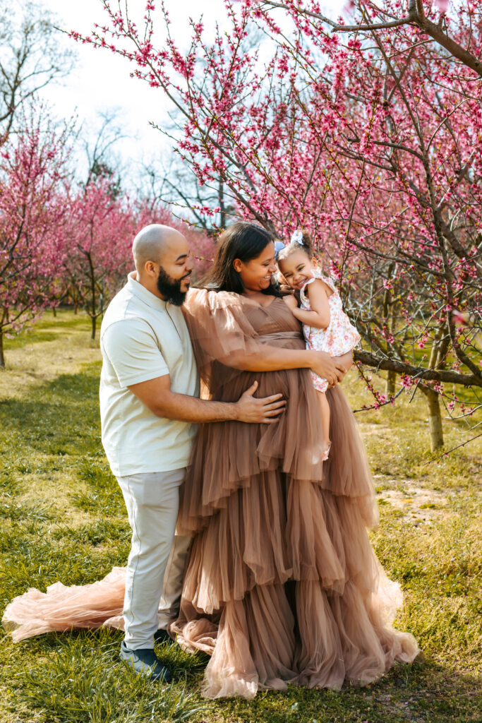 Family of three Maternity Session amid the Peach blooms at Millstone Creek Orchard - Photo By RattTrap Artistry 