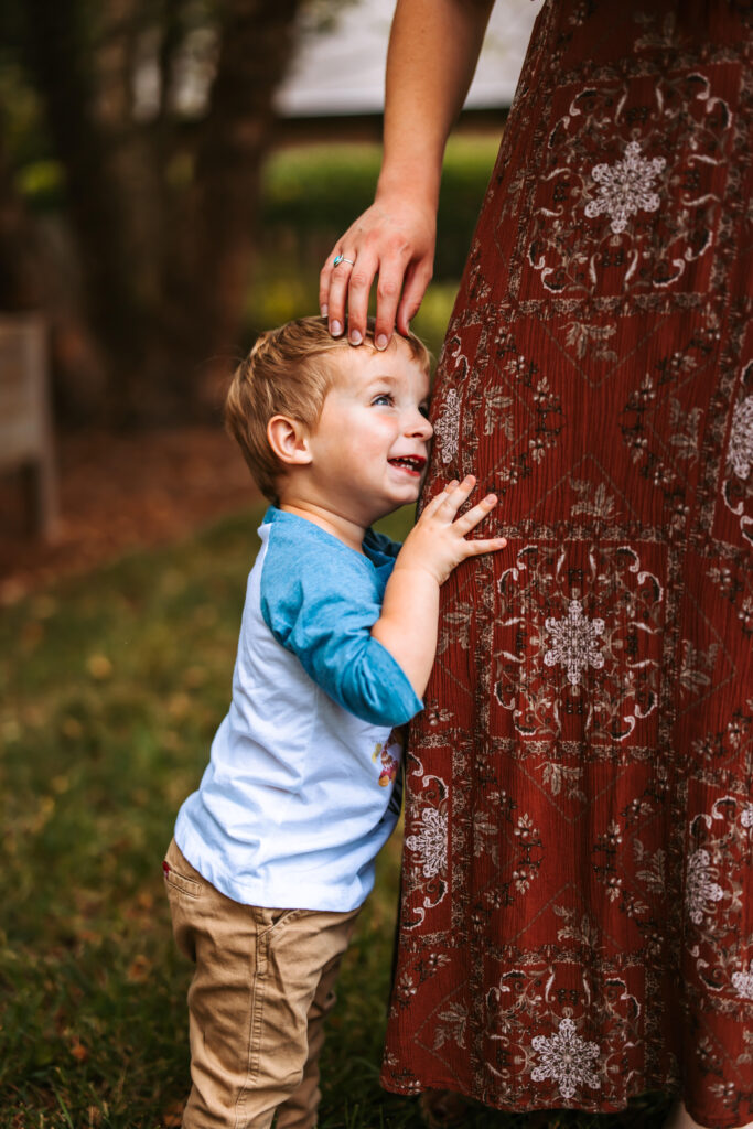 Son hugging mamas leg, at home family photos session in High Points, North Carolina 