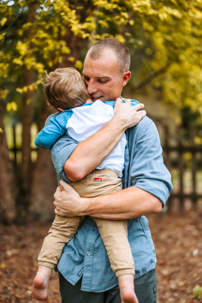 Young Boy hugging his dad, at home family photos session in High Points, North Carolina 