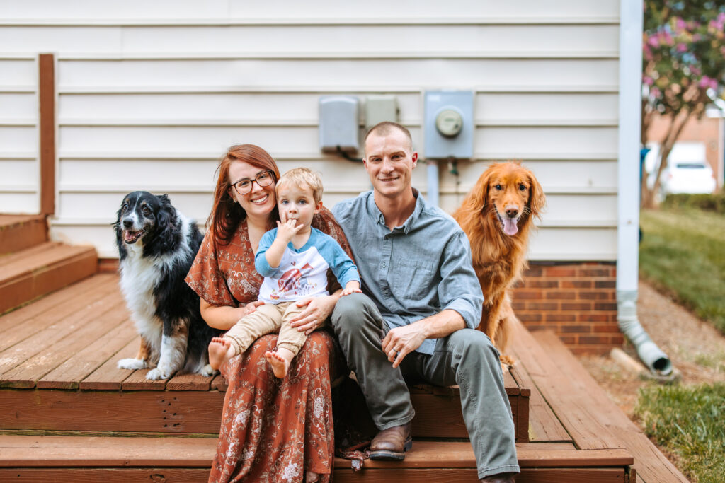 Family and their pups on porch at home family photos session in High Points, North Carolina 