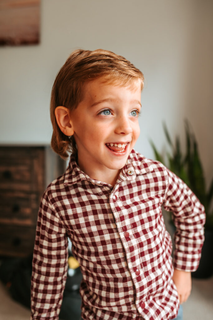 Excited big brother for photos with baby sister for their in home newborn session 