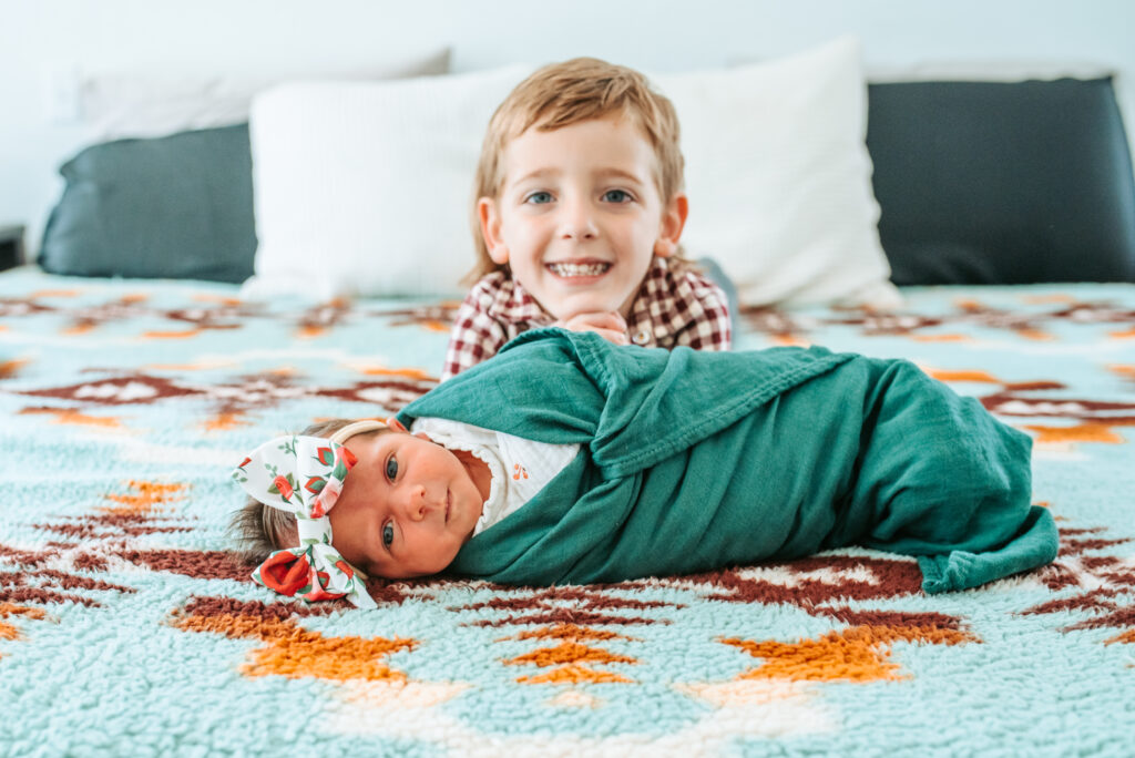 Proud big brother with his new baby sister at their in home newborn session 