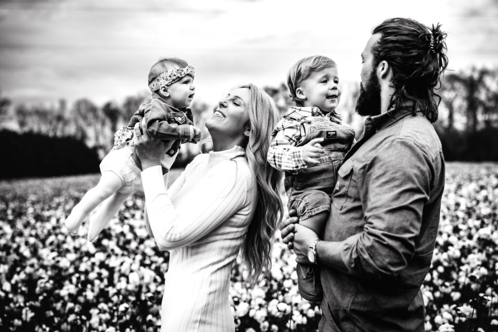 Family embracing and cherish all the moments with their little in a field of cotton in North Carolina 