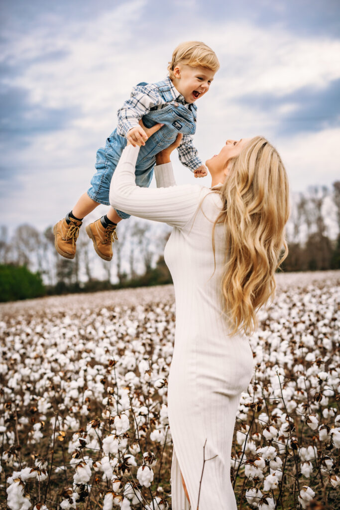 Mother holding son in the area at winter family session in a field of cotton in north carolina 