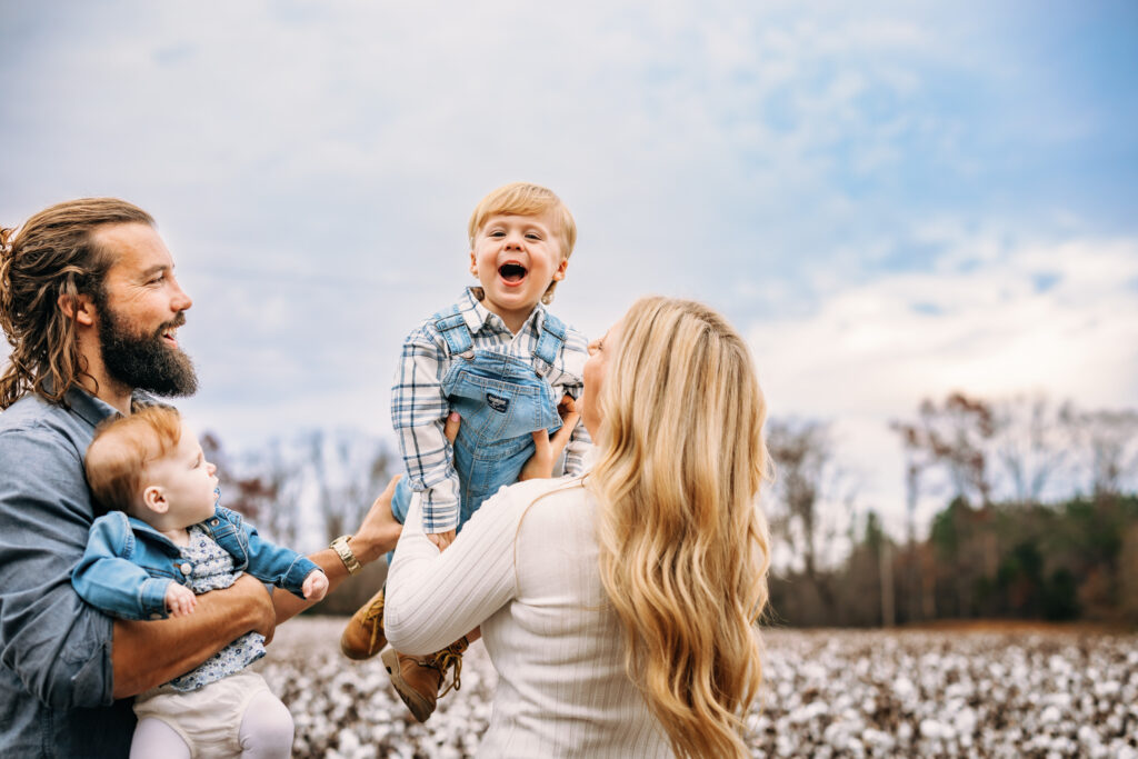 Little boy screaming with joy as his mother holds him in the air at family session in North Carolina 