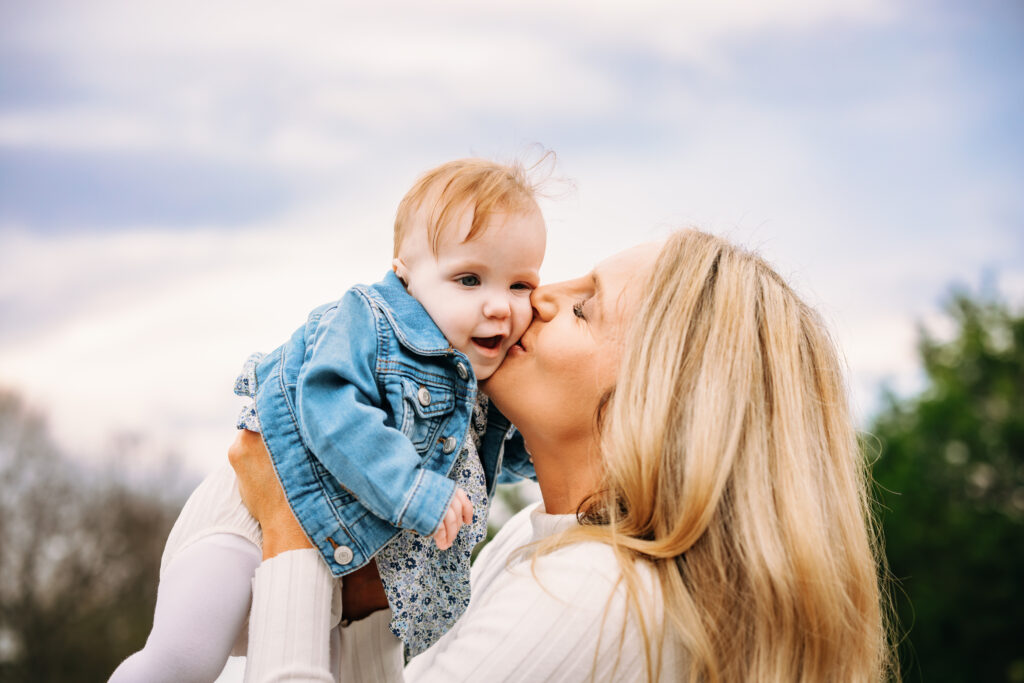 Mother kissing daughter durning winter family session in North Carolina 