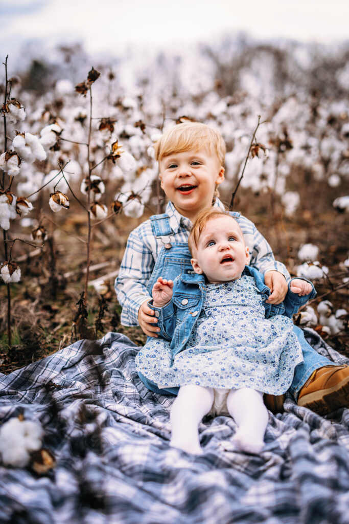 Siblings on a blanket surrounded by a field of cotton at Family Session with North Carolina Photographer 